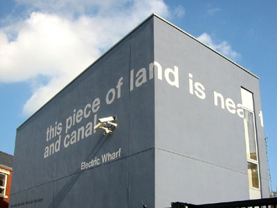 Electric Wharf site showing lettering on buildings, lead artist David Patten and Larry Priest of Bryant Priest Newman Architects. Electric Wharf, Coventry, 2001 - 2006. Photo: David Patten.